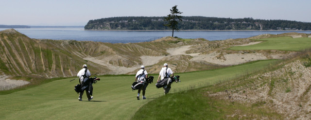 ** ADVANCE FOR JUNE 16-17 WEEKEND EDITIONS ** A group of caddies carry golf bags as they walk toward the lone tree of the Chambers Bay Golf Course Wednesday, May 30, 2007, in University Place, Wash., near Tacoma, Wash. The $21 million Scottish-links-style course will open to the public on June 23, 2007, is an anomaly -- a publicly financed, municipally owned, high-end links golf course. No golf carts are permitted, unless a golfer has a doctor's note. (AP Photo/Ted S. Warren)