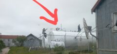 Workers on top of large white storage tank